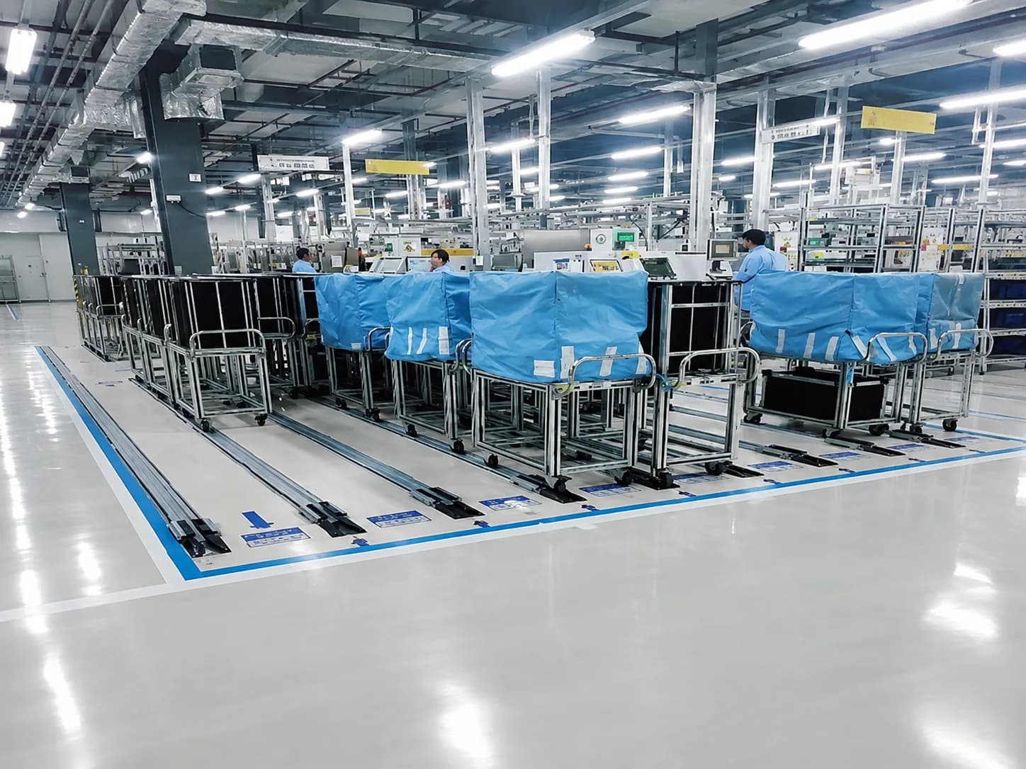 Transfer trolleys operating with floor guide rails in a FIFO-oriented workshop material-flow application