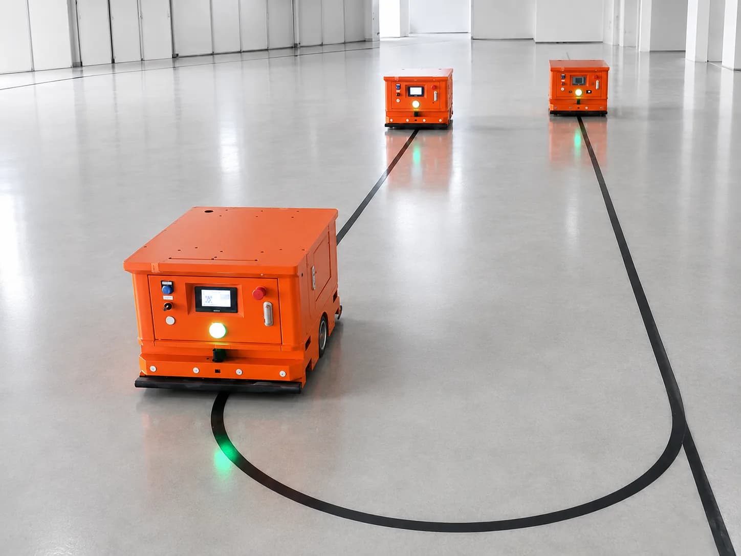 Multiple AGVs operating along defined workshop routes for material transfer applications